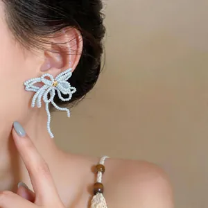 Vue détaillée d'une élégante boucle d'oreille nœud en perles de verre sur un mannequin