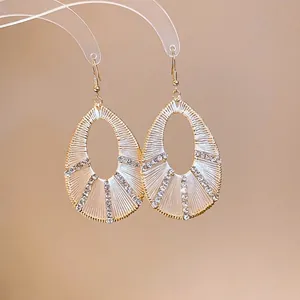 Eleganti orecchini pendenti a goccia di strass con finitura dorata e trama cava