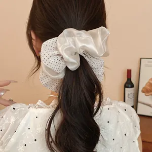 Close-up of white polka dot mesh and satin double-layer hair scrunchie on ponytail