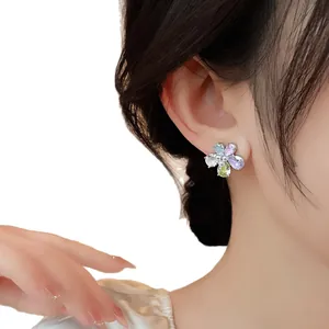 Vibrant colorful zircon flower stud earrings with pearl center shown on model ear
