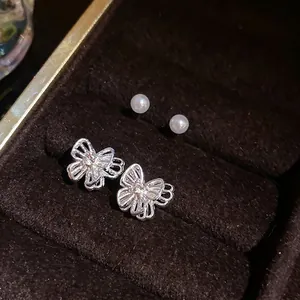 Elegant sterling silver butterfly stud earrings with sparkling rhinestones and white pearls