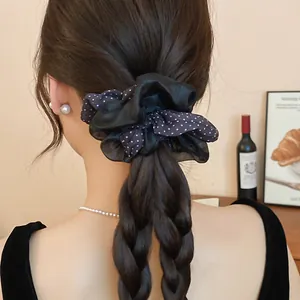 Close-up of double-layered polka dot and sheer black scrunchie on braided hair