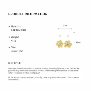 Detail view of yellow floral pearl drop earrings with size and material specifications