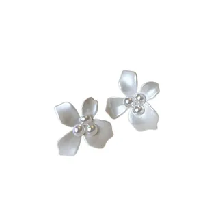 Elegant white flower shaped stud earrings with lustrous central pearls on white background