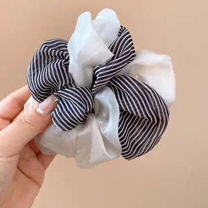 Detail of elegant black and white striped fabric double-layered hair scrunchie.