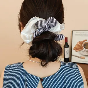 Close-up view of double-layer striped and white fabric scrunchies in a hair bun