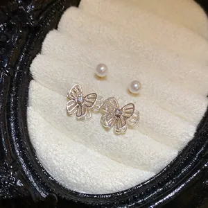Detailed macro shot of elegant silver butterfly and pearl stud earrings set in jewelry box