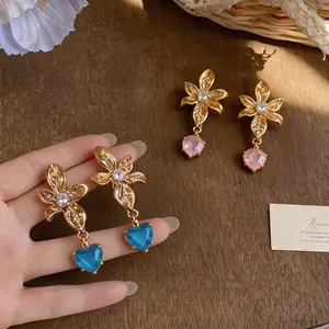 Elegant 18k gold plated flower stud earrings with dangling heart stones and clear zircons.