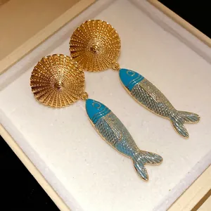 Elegant vintage-style fish drop earrings with golden textured studs in a jewelry box
