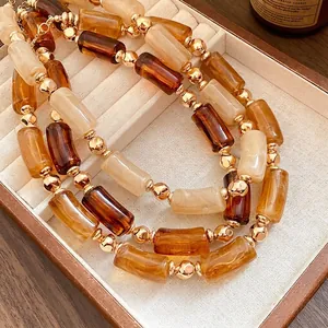 Elegante collana di perle cilindriche in acrilico stile Maillard con accenti dorati in scatola