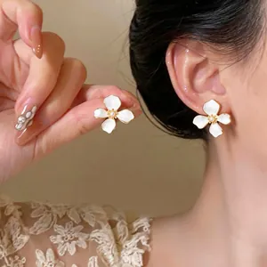 Elegant 18k gold plated flower earrings with pearl accent and white enamel finish