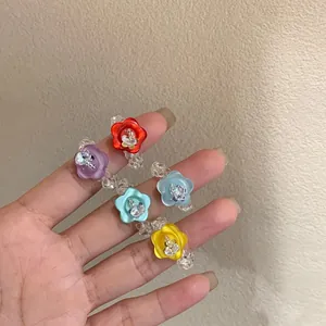 Detailed view of colorful handmade resin flower rings with sparkling rhinestone accents