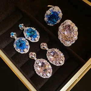 Macro di anelli e orecchini in zircone ovale blu e rosa in scatola di lusso