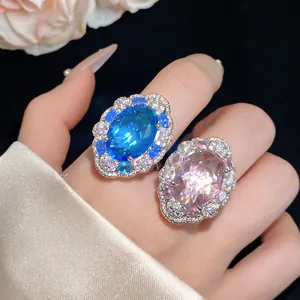 Primo piano di lussuosi anelli con zirconi ovali blu e rosa e cristalli micro-pave