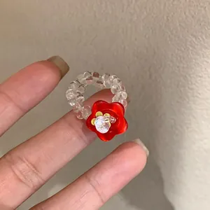 Close-up of handmade beaded resin ring with red flower button and rhinestone