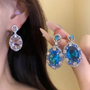 Dettaglio ravvicinato di orecchini pendenti vintage con zirconi ovali blu e rosa brillanti