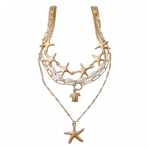 Multi-layered gold necklace with starfish, turtle pendants and pearl beads for vacation.
