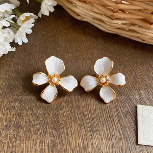 Close-up of elegant 18k gold plated flower earrings with a pearl center accent