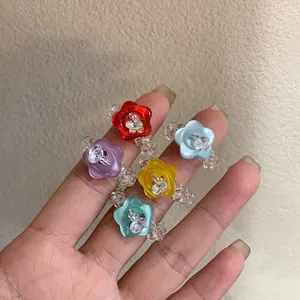 Close-up detail of handmade colorful resin flower rings with clear beaded bands