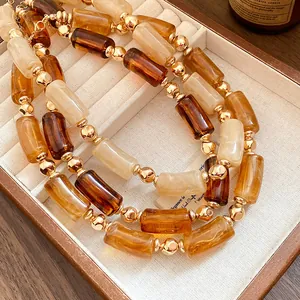 Dettaglio della collana Maillard in acrilico retrò con eleganti perle ambra e crema