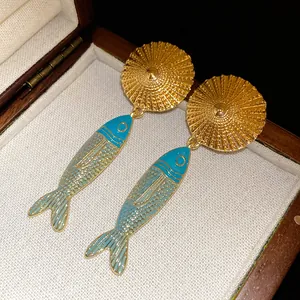 Detailed view of vintage ethnic style enamel fish drop earrings with golden sunburst studs