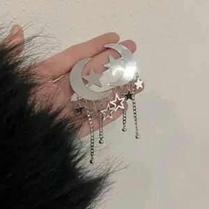 Statement silver moon and star tassel earrings with elegant fringe detail shown on hand