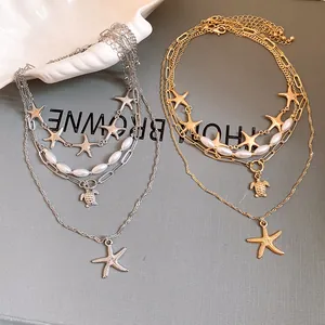 Detailed view of elegant gold and silver layered starfish necklaces with imitation pearl beads