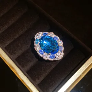 Primo piano di un anello ovale con zircone blu e accenti di diamanti in scatola