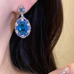 Dettaglio di eleganti orecchini ovali con zircone blu e montatura vintage