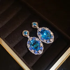 Vista dettagliata di orecchini di lusso con zirconi blu e alone scintillante in box