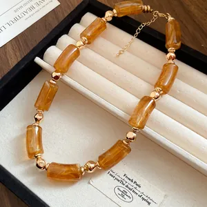 Dettaglio di una collana vintage in perle acriliche ambrate in una scatola portagioie