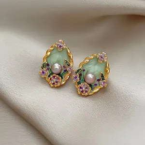 Detailed view of vintage court style enamel floral earrings with a central pearl.