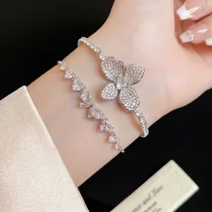 Elegante set di bracciali in zircone con fiori e cuori mostrato sul polso.