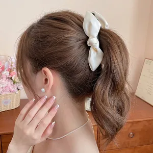 Eleganter Bananen-Haarclip mit cremefarbener Satinschleife für schicke Pferdeschwänze
