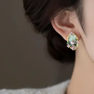 Detailed view of a vintage Monet garden floral enamel earring with a pearl accent