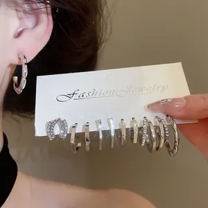 Close-up detail of a silver geometric earring set with sparkling rhinestones on display card