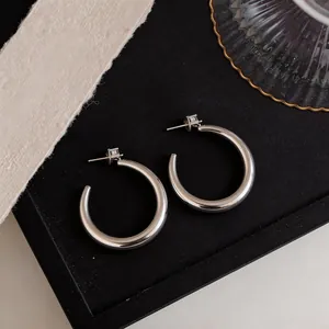 Eleganti orecchini a cerchio in argento con zirconi su vassoio nero