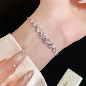 Elegante bracciale a scorrimento in zircone argento con dettagli a cuore e fiocco