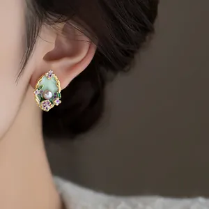Detailed close-up of a vintage Monet garden pearl earring with colorful enamel flowers