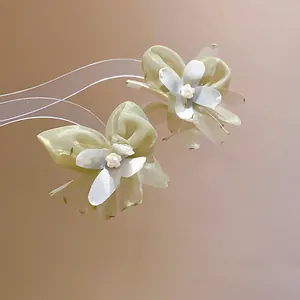 Elegant green mesh flower earrings with central pearls, close-up detail shot.