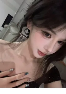 Close-up view of elegant silver moon and star tassel earrings being worn by a female model