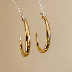 Dettaglio di questi orecchini a cerchio placcati oro 18k con zircone scintillante