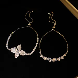 Primo piano di squisiti braccialetti regolabili in zircone con fiori e fiocchi su velluto nero.