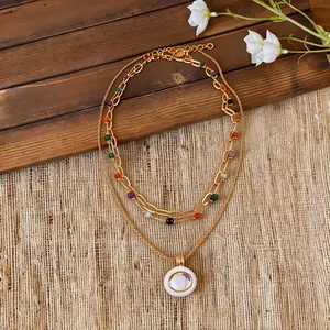 Ethnic multi-layer gold necklace with colorful beads and iridescent circular pendant