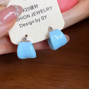 Detail view of light blue enamel U-shaped hoop earrings with S925 silver posts on card