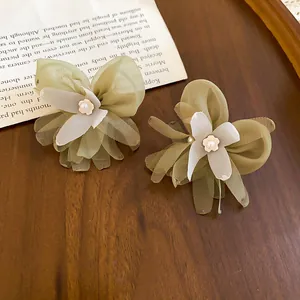 Detailed view of green mesh flower stud earrings featuring elegant central pearl accents