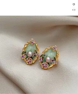Exquisite close-up of vintage floral enamel earrings with pink pearls and gold borders