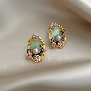Detailed close-up of vintage floral enamel pearl earrings in a Monet garden style design