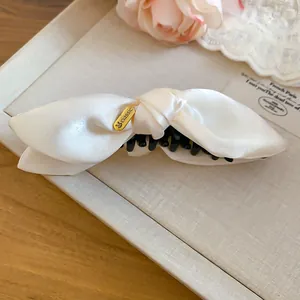 Detailansicht der cremefarbenen Satin-Schleife-Banane-Haarklammer mit elegantem Knoten