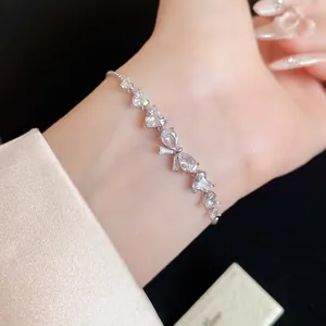 Primo piano di un braccialetto regolabile in zircone con pietre a forma di cuore e fiocco